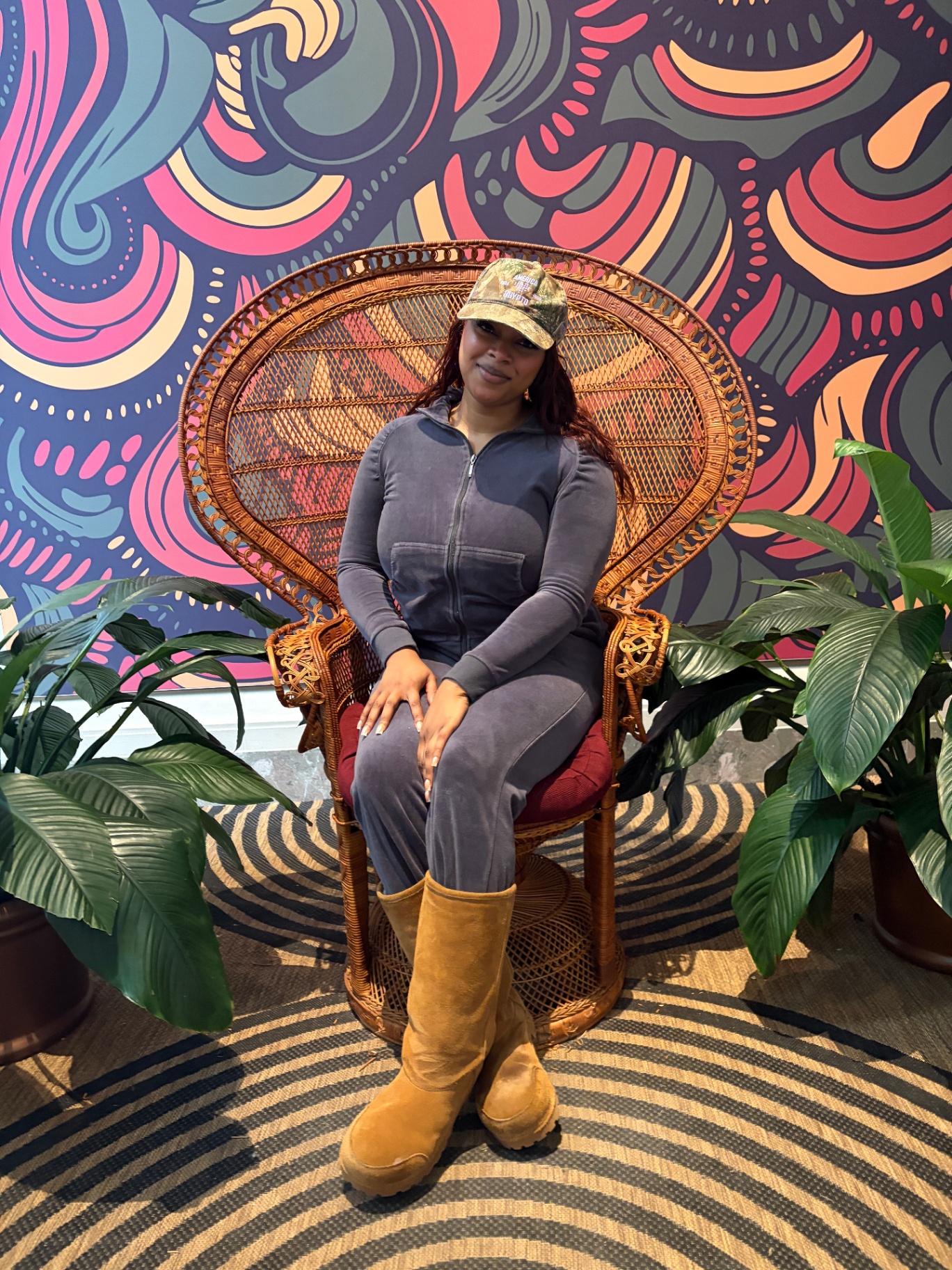 A confident person sitting in a woven chair against a colorful mural, representing taking control of your finances